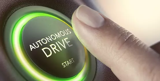 Finger pressing a push button to start a self-driving car. 