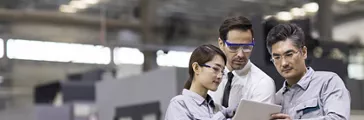 Businessman and engineers talking in the factory