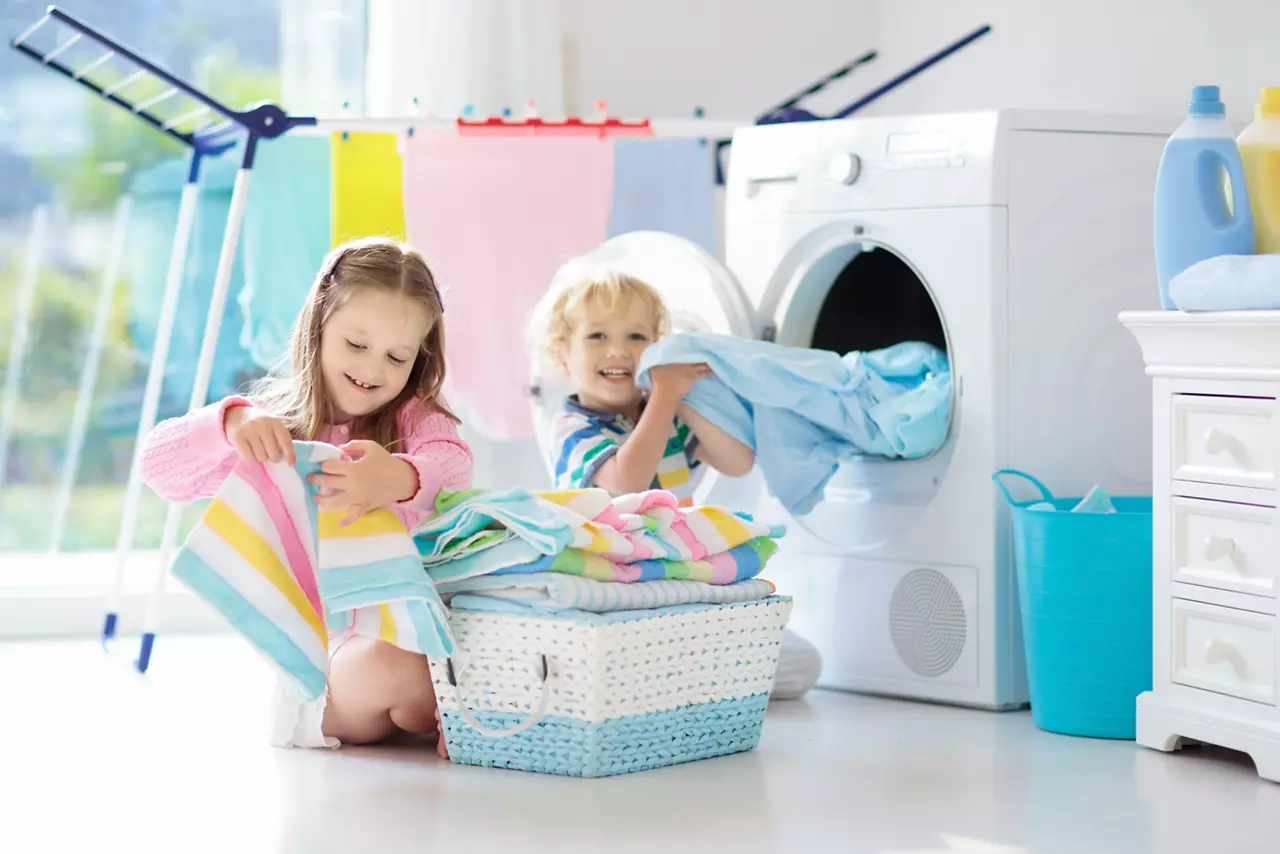 Enfants dans la buanderie aidant à la lessive