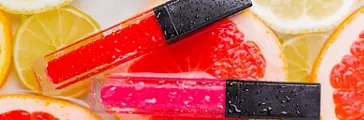 Lip gloss and citrus fruits . The concept of an unnamed lipstick bottle. Cosmetology. Decorative cosmetics. Fruit | rotated
